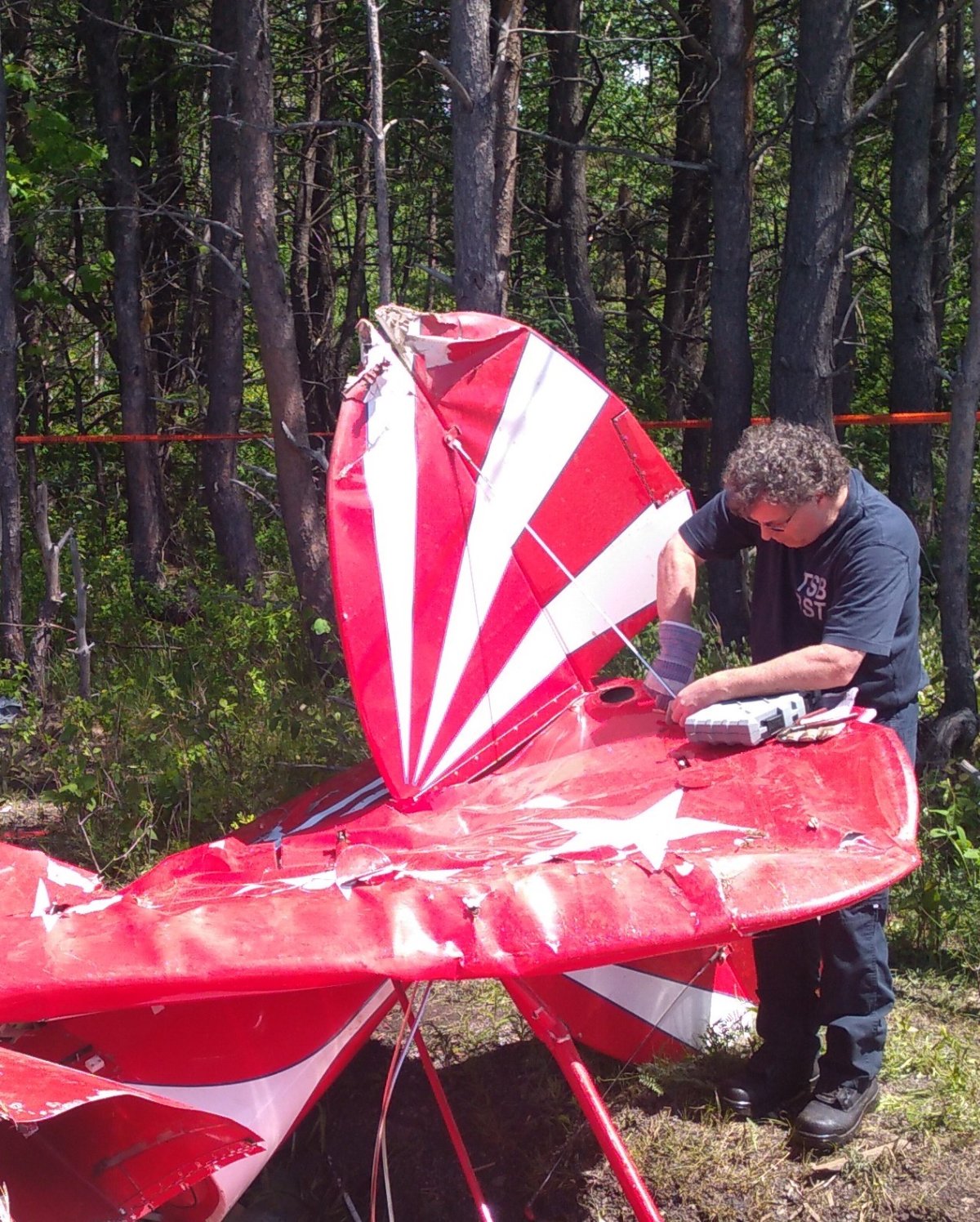 A Transportation Safety Board investigator examines the wreckage of a Pitts S2E aircraft following an accident in Saint-Jean-Port-Joli, Que., in this 2019 handout photo. 