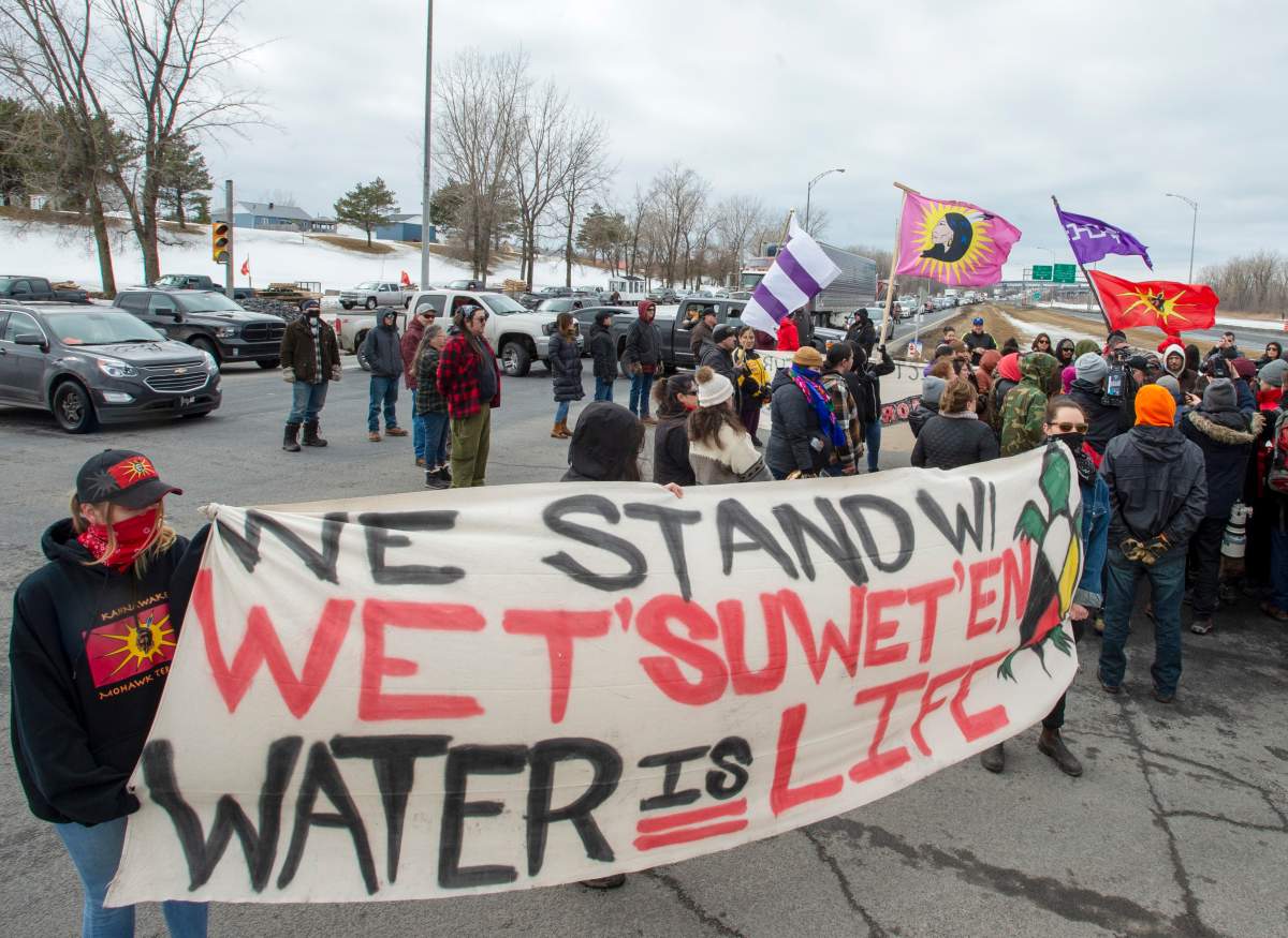 Members of the Mohawk community briefly block the highway to read a statement after removing their blockade of the commuter rail line, Thursday, March 5, 2020 in Kahnawake, Que.