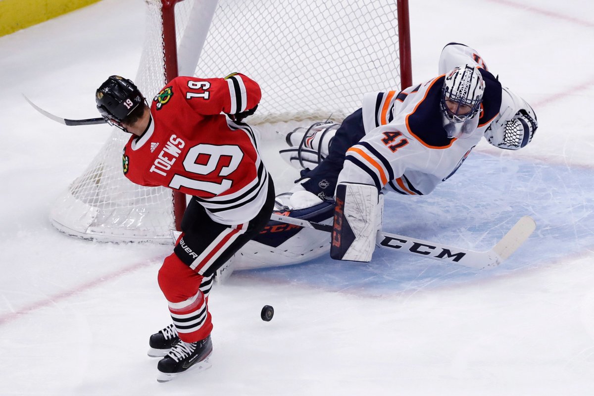 Edmonton Oilers goalie Mike Smith, right, blocks a shot by Chicago Blackhawks center Jonathan Toews during the first period of an NHL hockey game in Chicago, Thursday, March 5, 2020.