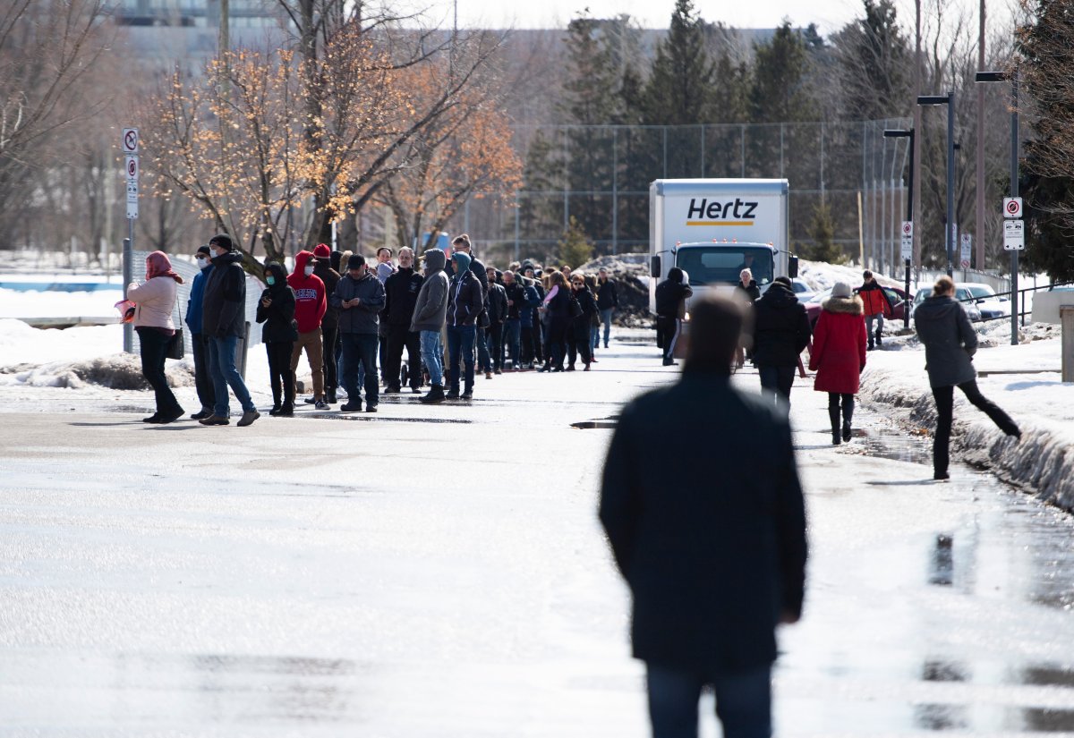 People line up outside of the COVID-19 Assessment Centre at Brewer Park Arena in Ottawa, 45 minutes after its scheduled opening on Friday, March 13, 2020.