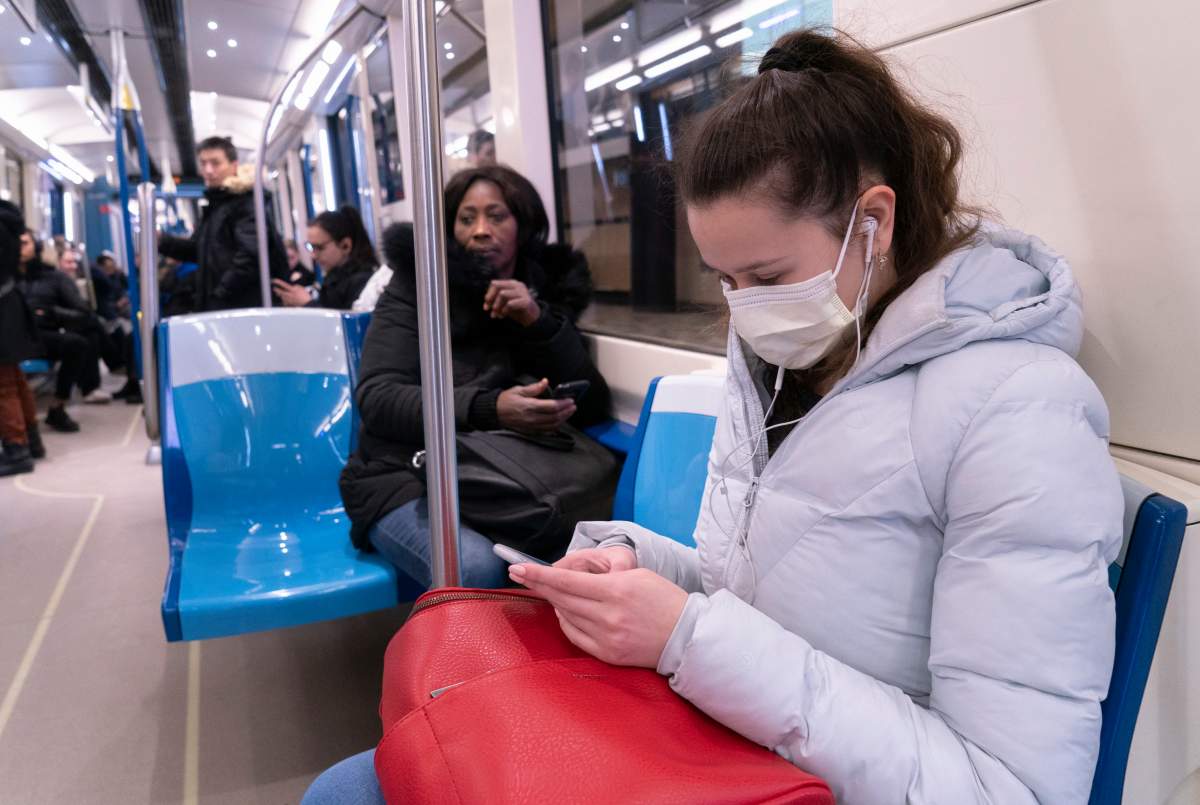 A commuter wears a protective mask as she rides the Metro in Montreal on Friday, March 13, 2020.