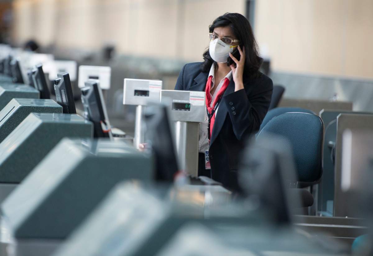An airline employee is seen at Vancouver International Airport in Richmond, B.C. Friday, March 13, 2020.