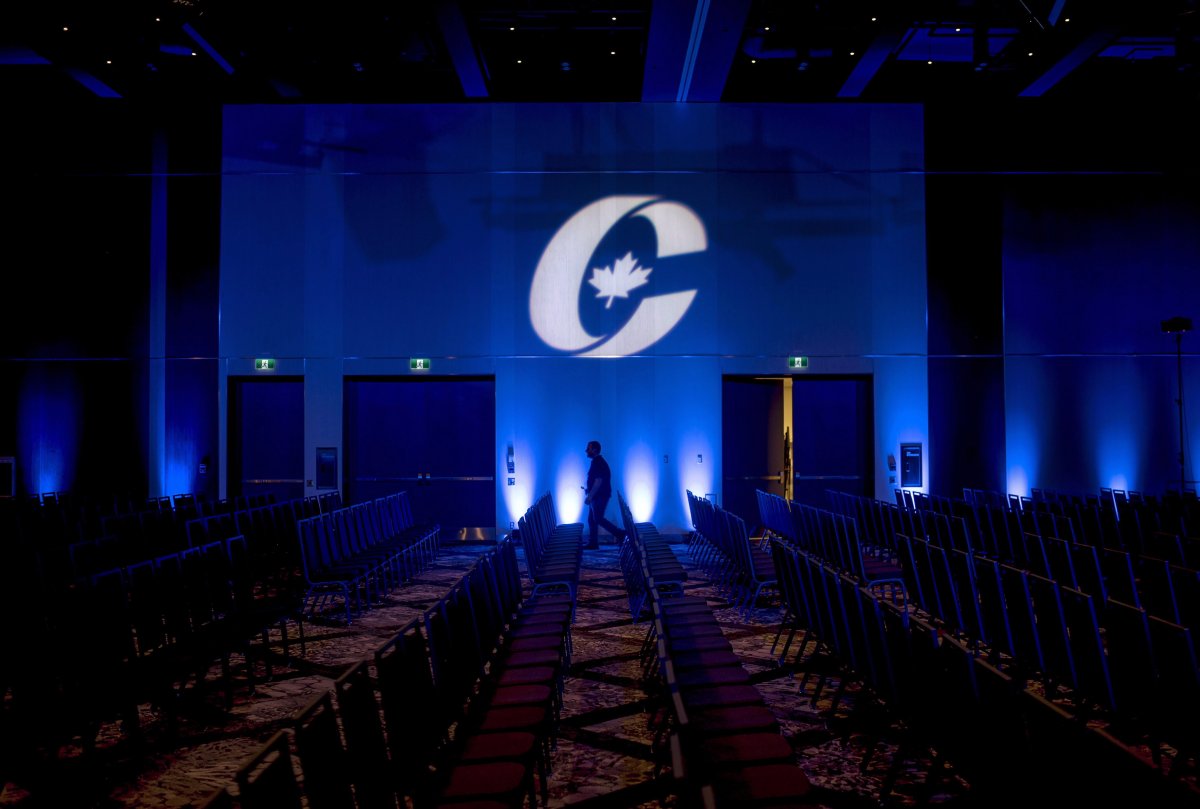 A man is silhouetted walking past a Conservative Party logo before the opening of the Party's national convention in Halifax on Thursday, August 23, 2018. 