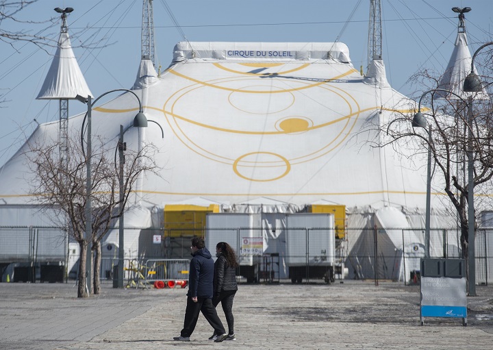 A man and woman walk by the Cirque du Soleil Big Top in Montreal's Old Port, Saturday, March 21, 2020, as COVID-19 cases rise in Canada and around the world.