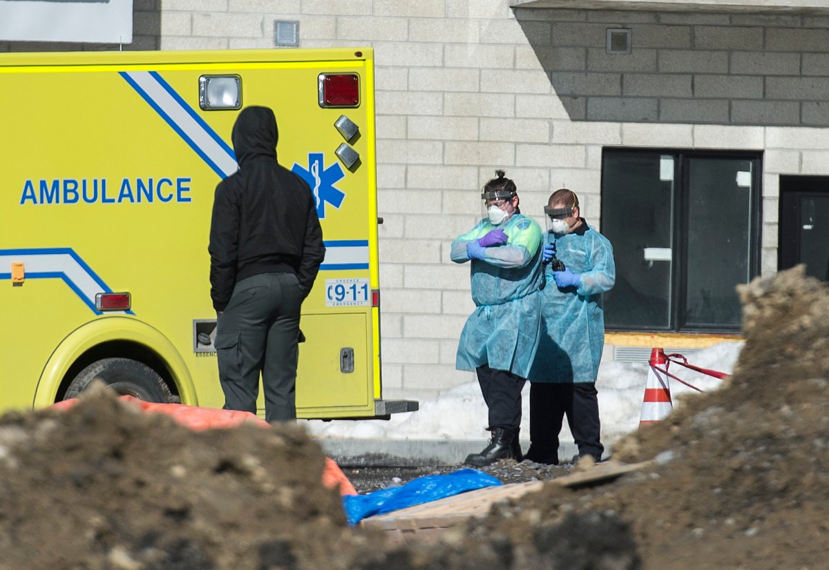 Emergency workers wearing protective masks, gloves and clothing are shown at Eva Lavaltrie seniors' residence in Lavaltrie, Que., Saturday, March 21, 2020.