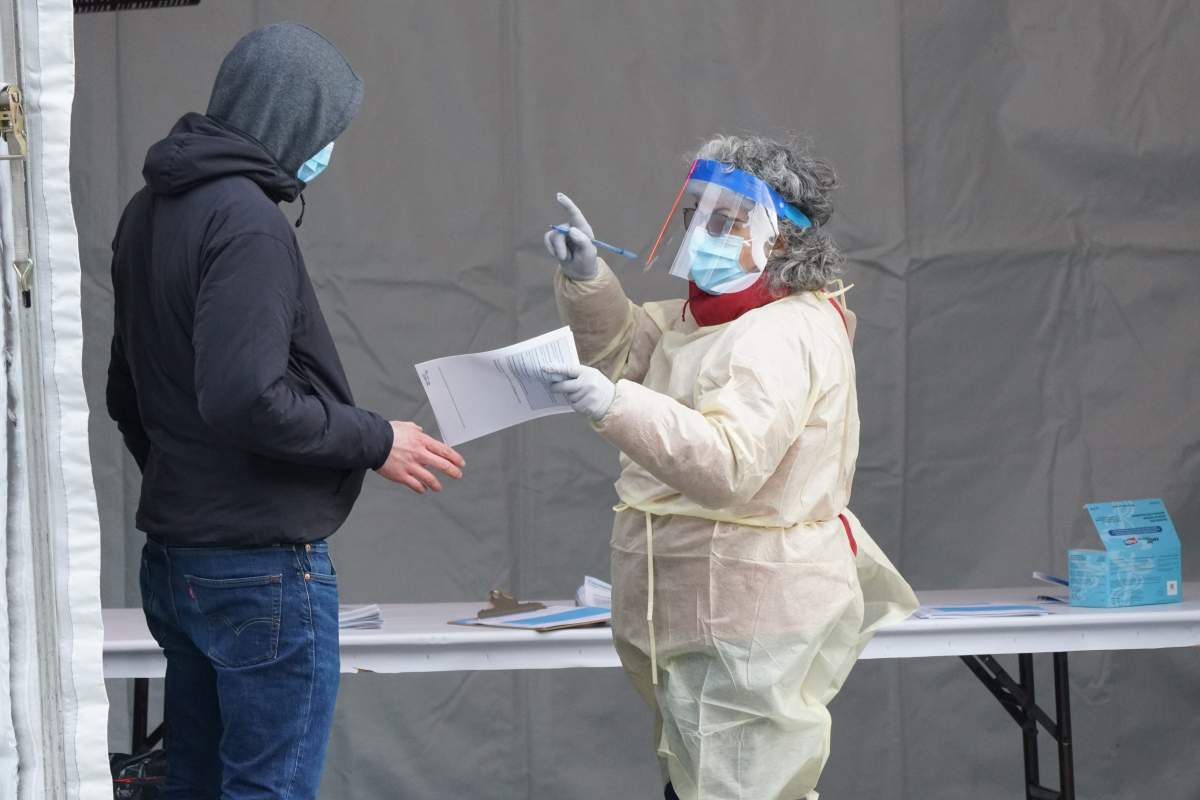 Healthcare worker directing a person for further testing at the COVID-19 outdoor emergency clinic in Montreal, Que., Monday, March 23, 2020.