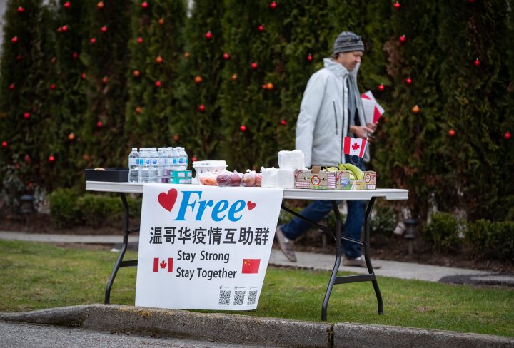 A man walks past a table of free food and hygiene products left outside by a resident, in Vancouver, on Monday, March 23, 2020. THE CANADIAN PRESS/Darryl Dyck.