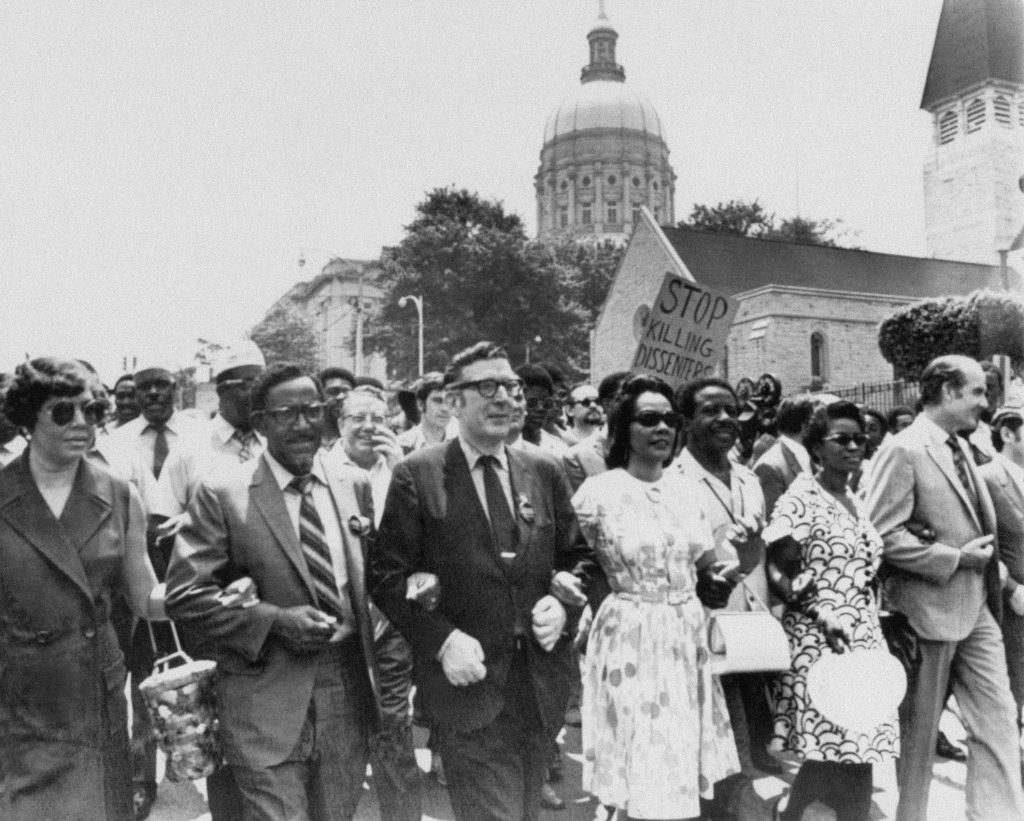 FILE – In this May 1970 file photo, Leonard Woodcock, newly elected president of the United Auto Workers Union, in glasses and dark suit, locks arms with Coretta Scott King, wife of slain the Rev. Dr. Martin Luther King Jr., and the Rev. Joseph E. Lowery as they lead several thousand marchers past the state Capitol in Atlanta in a protest march against war, violence and racial repression. Lowery, a veteran civil rights leader who helped the Rev. Dr. Martin Luther King Jr. found the Southern Christian Leadership Conference and fought against racial discrimination, died Friday, March 27, 2020, a family statement said. He was 98.