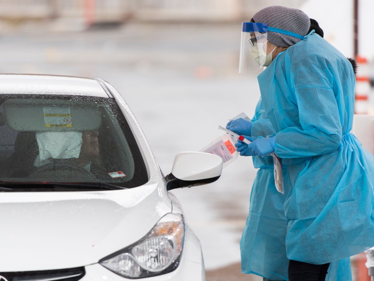 A health care worker talks to a driver at a drive-thru COVID-19 test clinic in Montreal, Sunday, March 29, 2020, as Coronavirus COVID-19 cases rise in Canada and around the world.