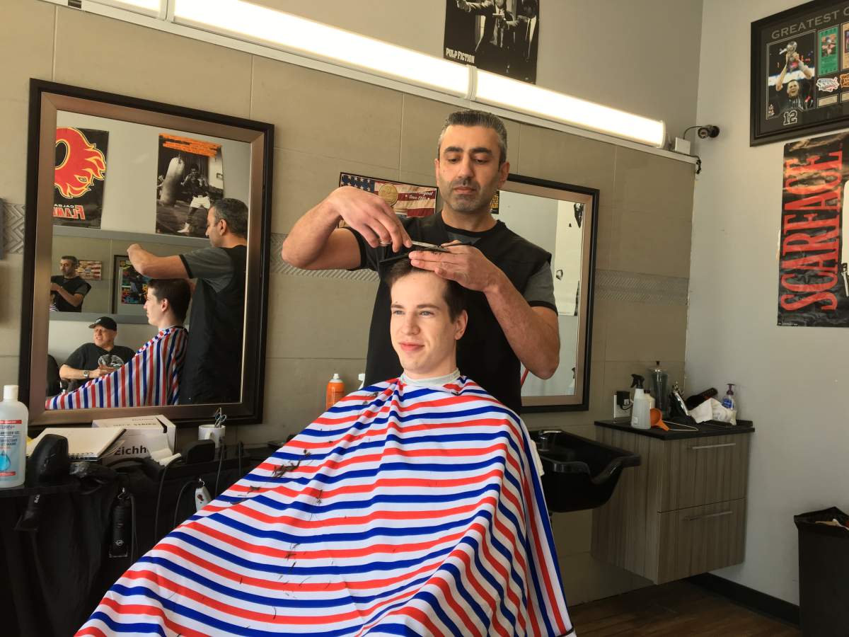 Moe Masri cuts a clients hair at Mayland Heights Barber Shop