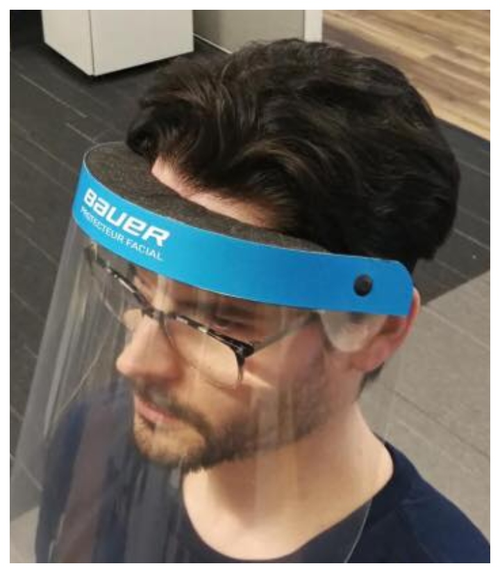 A man demonstrates a medical face shield produced by Bauer Hockey.