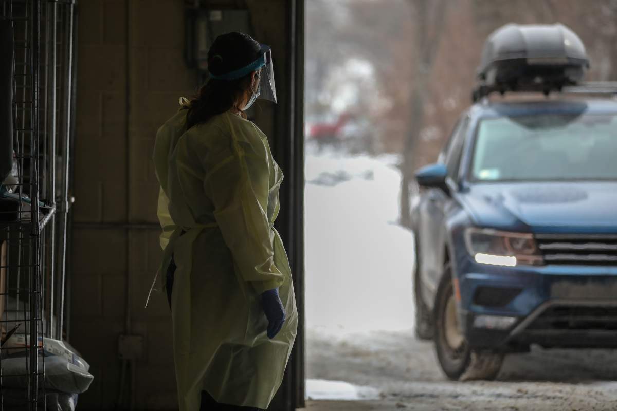 An AHS worker at a COVID-19 drive-thru testing centre in Calgary, Alta.