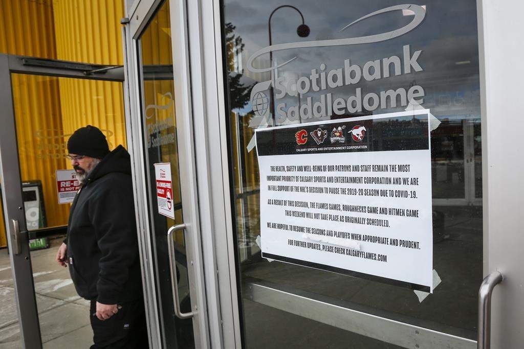 Signs on the doors of the Saddledome, home of the Calgary Flames, are seen in Calgary on March 12, 2020.