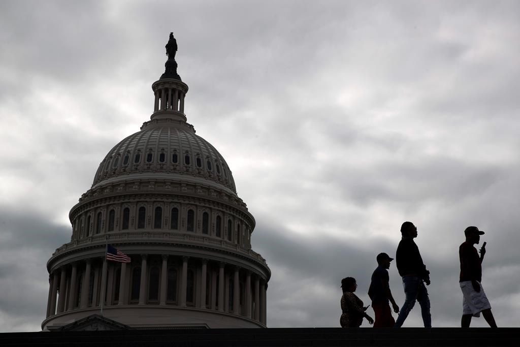 Visitors walk past the U.S. Capitol dome on Capitol Hill in Washington, March 12, 2020.