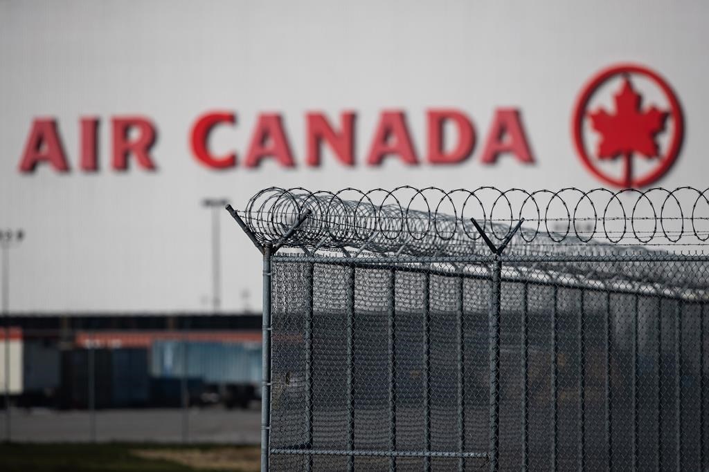 An Air Canada hangar is seen behind a security fence at Vancouver International Airport, in Richmond, B.C., on Friday, March 20, 2020.
