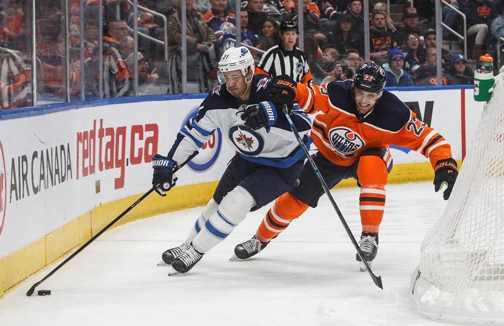 The Winnipeg Jets' Nicholas Shore is chased by Edmonton Oiler Riley Sheahan during third-period NHL action in Edmonton, Alta., on Wednesday, March 11, 2020.