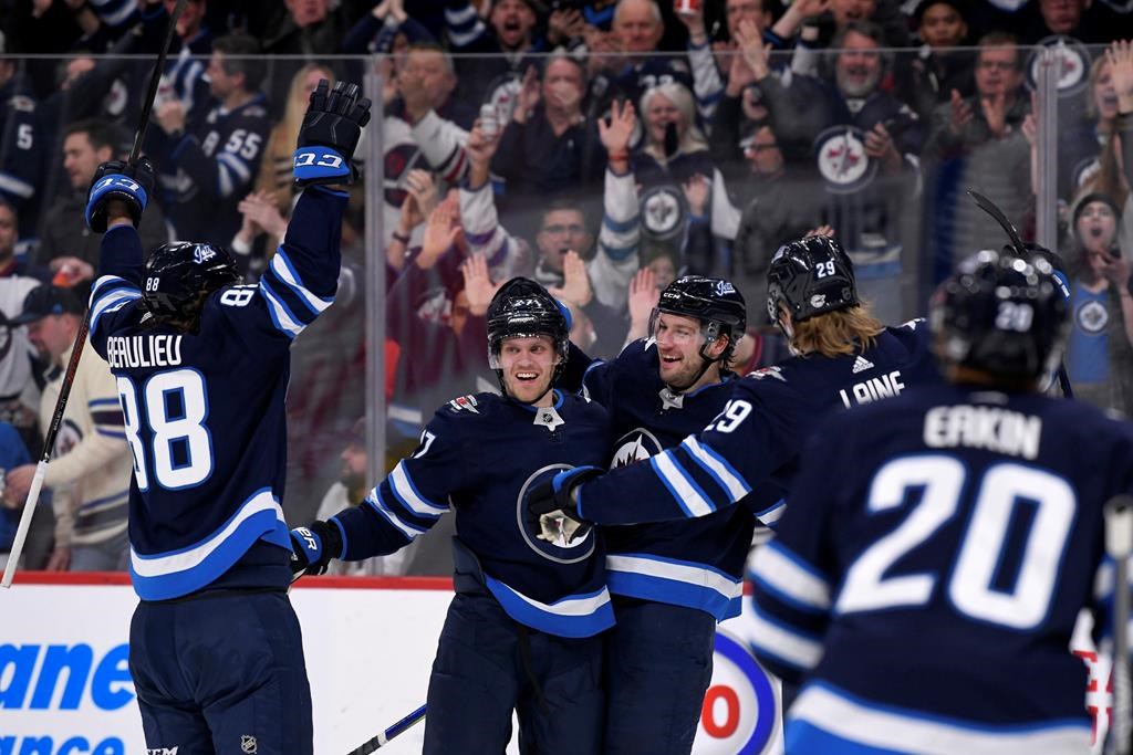Winnipeg Jets' Tucker Poolman, centre, celebrates his goal against the Arizona Coyotes with teammates Nathan Beaulieu, left, Nikolaj Ehlers, second left, and Patrik Laine, second right, during second period NHL action in Winnipeg on Monday, Mar. 9, 2020. THE CANADIAN PRESS/Fred Greenslade.