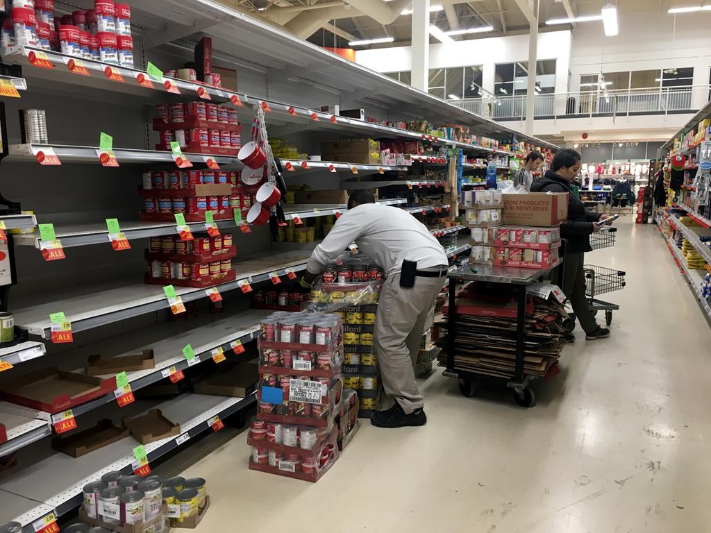 Workers restock grocery store shelves with canned goods early in the morning in this file photo.