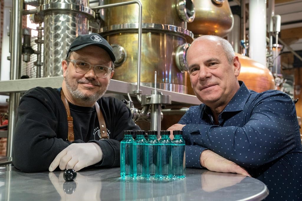 Spirit of York Head Distiller Mark Harrop (left) and founder Gerry Guitor pose with bottles of distillery-made hand sanitizer in Toronto on Wednesday March 18, 2020.
