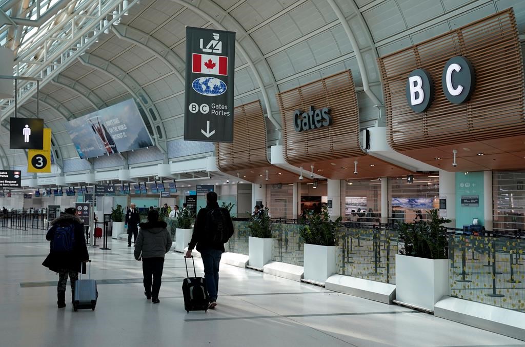 Travellers walk through Terminal 3 at Pearson International Airport in Toronto, Friday, March 13, 2020. Provincial governments have advised against international travel and Ontario announced plans to close its schools for two weeks because of COVID-19.THE CANADIAN PRESS/Frank Gunn.