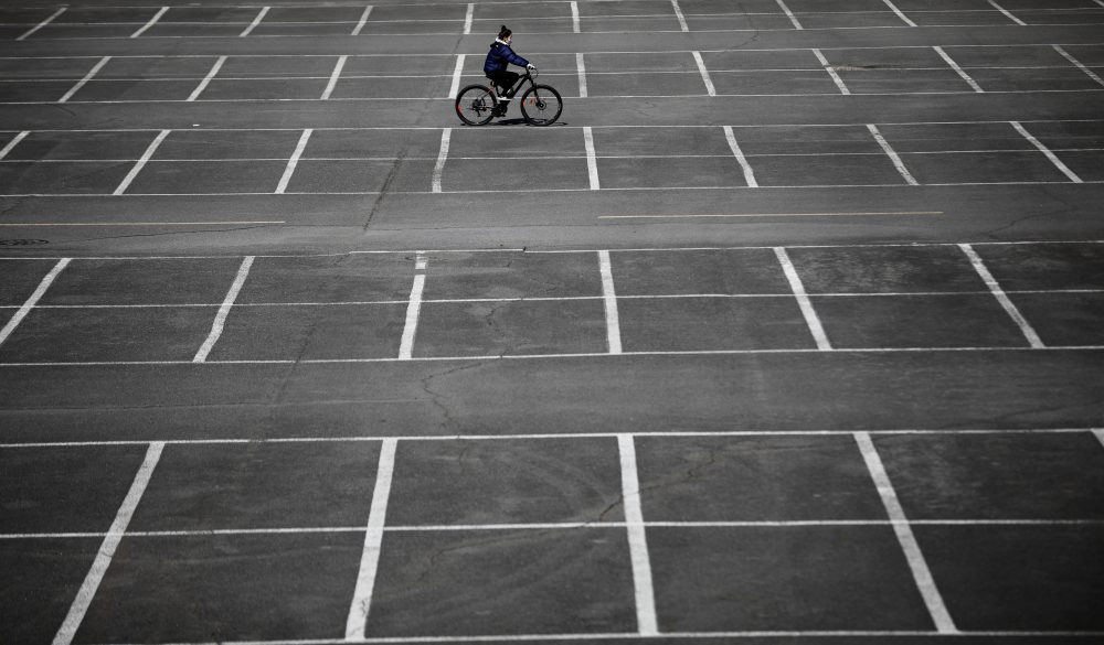 A woman wearing a protective mask following an outbreak of the novel coronavirus disease rides a bicycle at an empty parking lot of an amusement park in Daegu, South Korea, March 12, 2020.