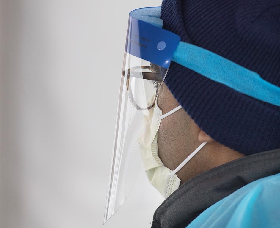 A healthcare worker looks on at a drive-thru COVID-19 test clinic in Montreal, Sunday, March 29, 2020, as Coronavirus COVID-19 cases rise in Canada and around the world.