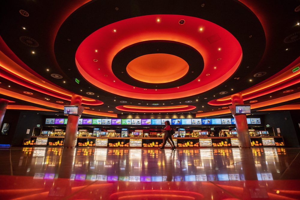 Customers walk in the empty hall of a movie theatre in Budapest, Hungary, March 12, 2020.