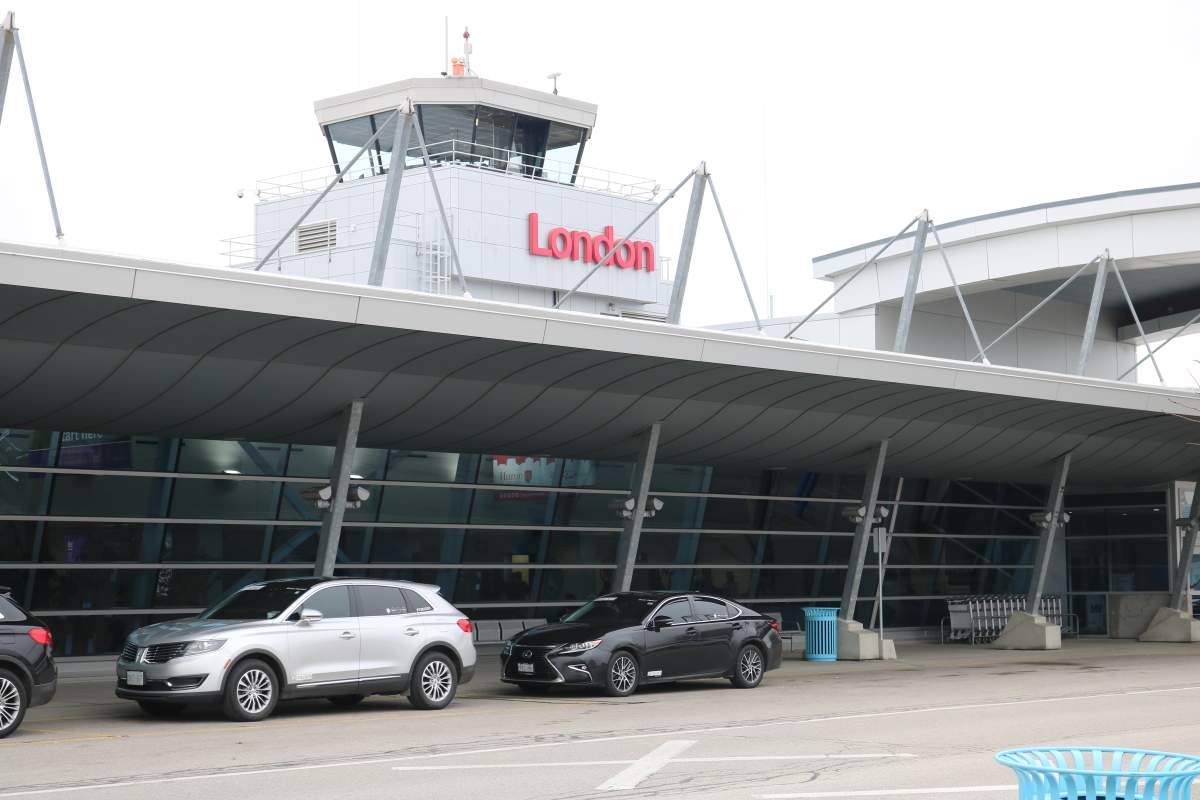A view of the London International Airport with vehicles parked in front.
