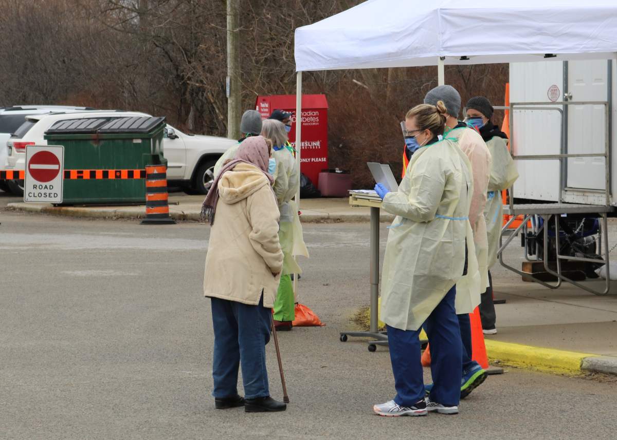 London Health Sciences Centre workers outside the COVID-19 Assessment Centre in London at the Oakridge Arena waiting to asses people waiting in line in March, 2020.