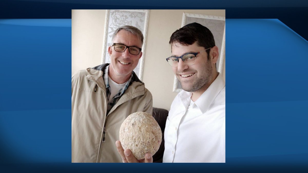 Uzi Rotstein, left, and Moshe Manies are shown with a recently returned ballista stone.