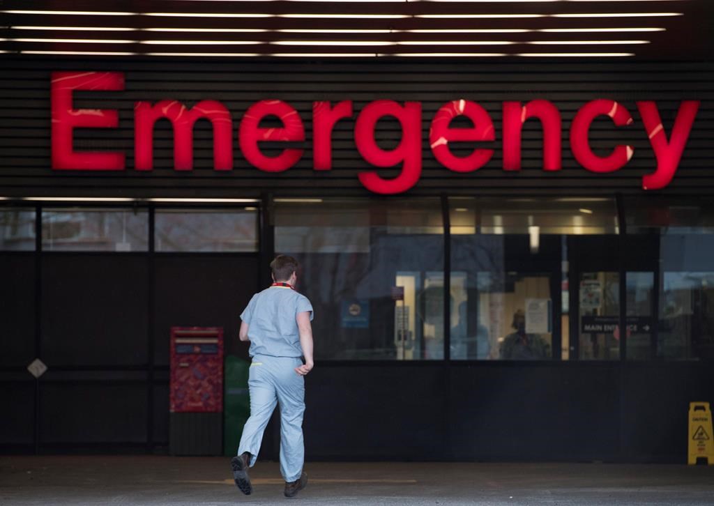 A health-care worker is seen making his way into the emergency department of the Vancouver General Hospital in Vancouver Monday, March 30, 2020.