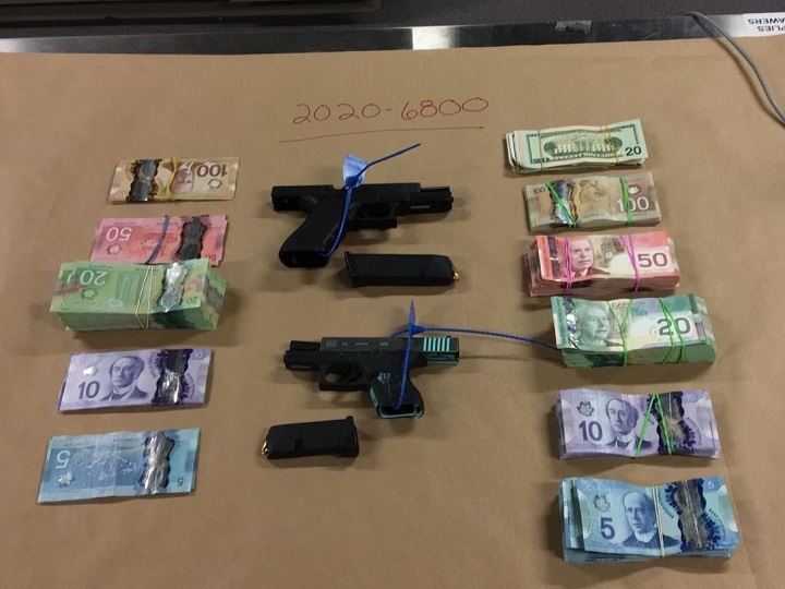 An RCMP photo showing two handguns plus Canadian and American currency that were seized during a search warrant in Kelowna last month.