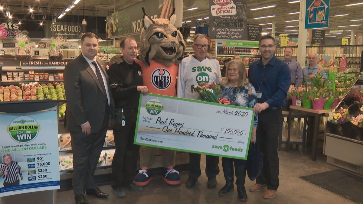 Paul Rogers receives his $100,000 cheque after Leon Draisaitl scored four goals on March 2. 