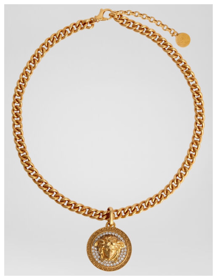 A Versace crystal pendant necklace is shown with a Medusa-head design.