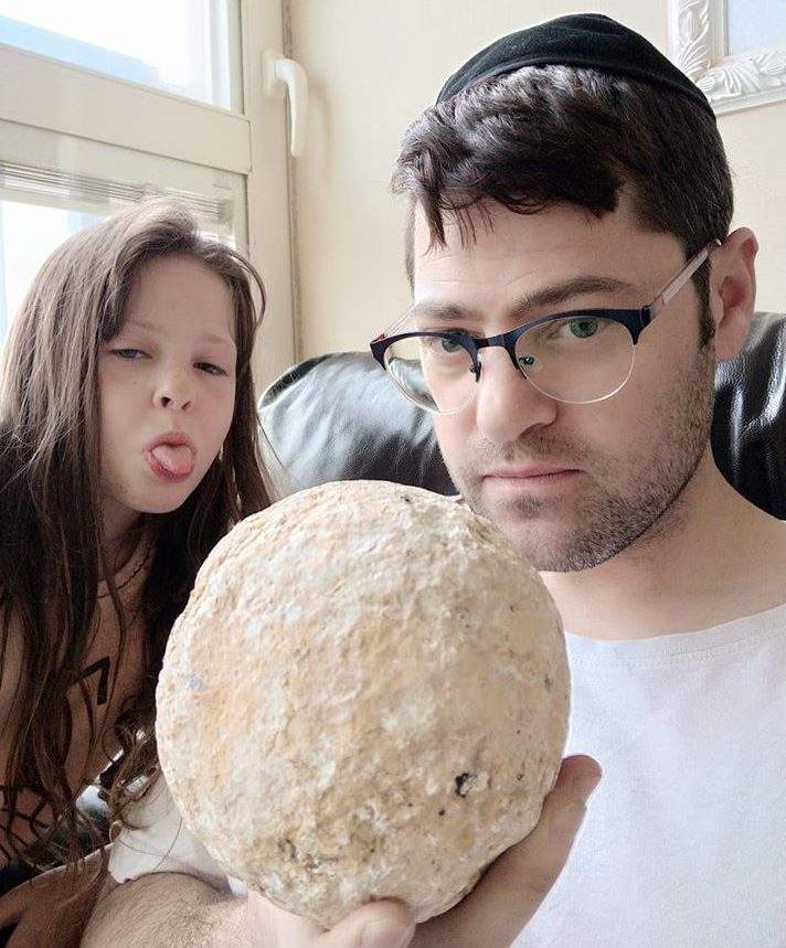 Moshe Manies, right, holds a Roman ballista stone.