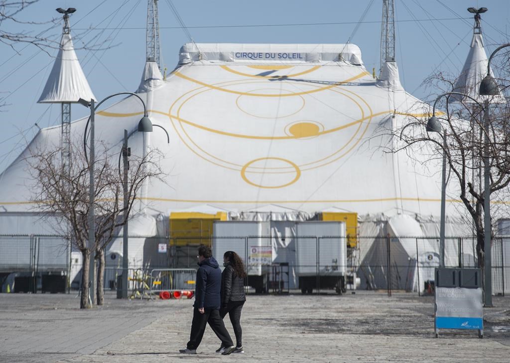 A man and woman walk by the Cirque du Soleil Big Top in Montreal's Old Port, Saturday, March 21, 2020.