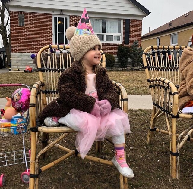 A Peterborough girl named Luna watches as a parade for her birthday drives by her house on Thursday, March 26.