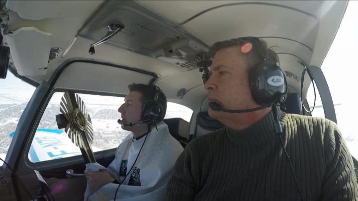 Father Matthew Ramsay prays for people of Saskatoon as he flies over the city.