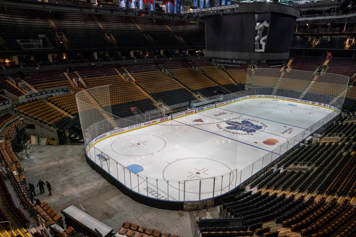 Workers stand by after pausing arena assembly for the Maple Leafs NHL hockey game against the Nashville Predators at Scotiabank Arena in Toronto on Thursday March 12, 2020.