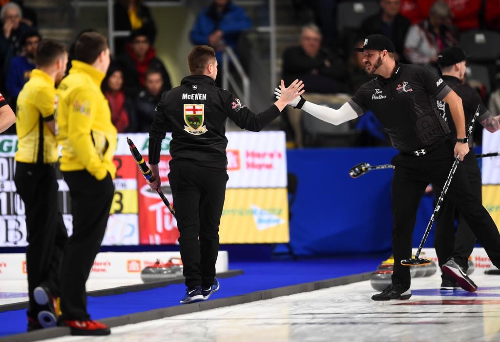 Team Wild Card skip Mike McEwen, middle, reacts with teammate second Derek Samagalski as they play Team Manitoba in the championship pool at the Brier in Kingston, Ont., on Thursday, March 5, 2020.