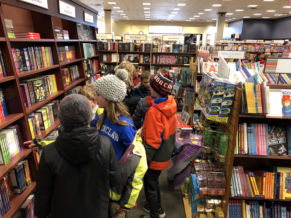 Keenooshayo Elementary School students picking out books for their project