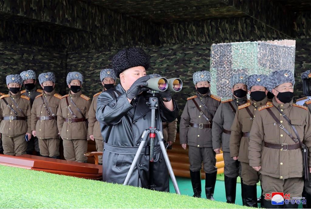 In this Friday, Feb. 28, 2020, file photo provided on Feb. 29, 2020 by the North Korean government, North Korean leader Kim Jong Un, center, inspects the military drill of units of the Korean People's Army, with soldiers shown wearing face masks. South Korea’s military says North Korea has fired at least one unidentified projectile.