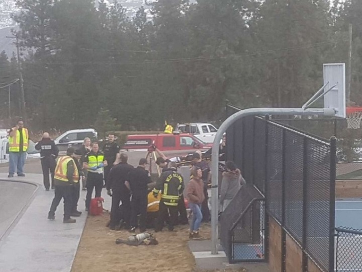 Members of West Kelowna Fire Rescue can be seen surrounding a maintenance hole while rescuing the boy.
