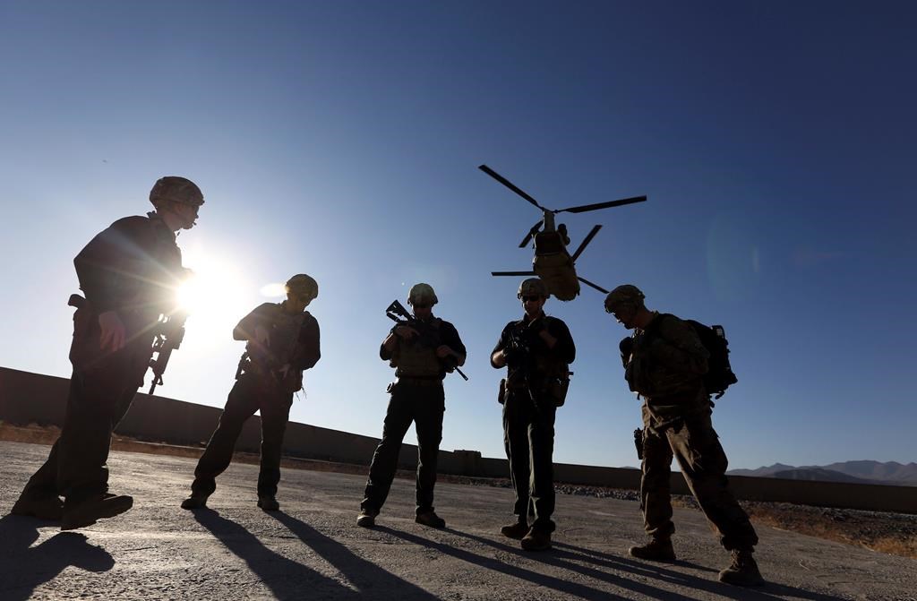 FILE - In this Nov. 30, 2017 file photo, American soldiers wait on the tarmac in Logar province, Afghanistan.