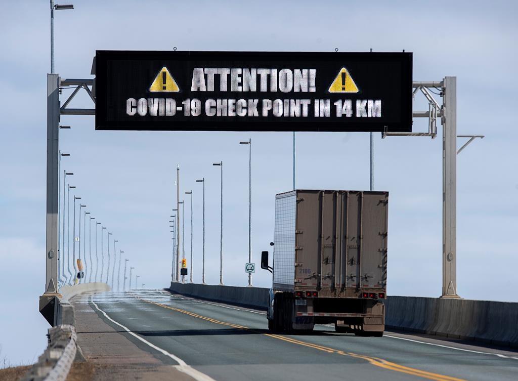 A sign indicates that provincial health department workers will stop traffic that has crossed the Confederation Bridge in Cape Jourimain, N.B. on Sunday, March 22, 2020.