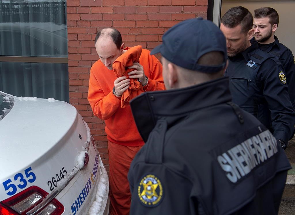 Matthew Vincent Raymond is taken from Court of Queen's Bench in Fredericton on Friday, March 13, 2020. The trial for Raymond, accused of killing two police officers and two civilians in the New Brunswick capital last year, is still an uncertainty as the state of his mental health is being considered. The province is also is suspending jury trials for two months over concerns about the potential spread of novel coronavirus. THE CANADIAN PRESS/Andrew Vaughan.