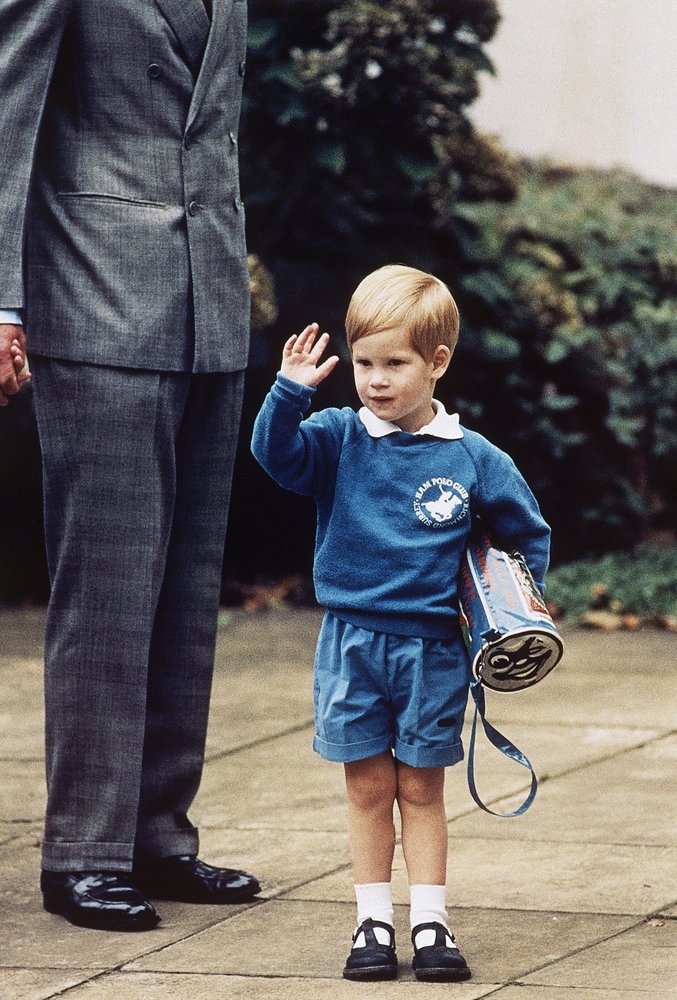 In this Sept. 16, 1987 file photo, Britain\’s Prince Harry waves to photographers whilst holding a Thomas the Tank Engine bag on his first day at a kindergarten in Notting Hill, West London. (AP Photo/Martin Cleaver, File)