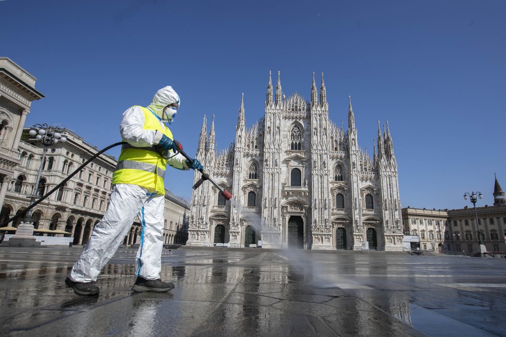 A worker sprays disinfectant to sanitize Duomo square, as the city main landmark, the gothic cathedral, stands out in background, in Milan, Italy, Tuesday, March 31, 2020. The new coronavirus causes mild or moderate symptoms for most people, but for some, especially older adults and people with existing health problems, it can cause more severe illness or death. 