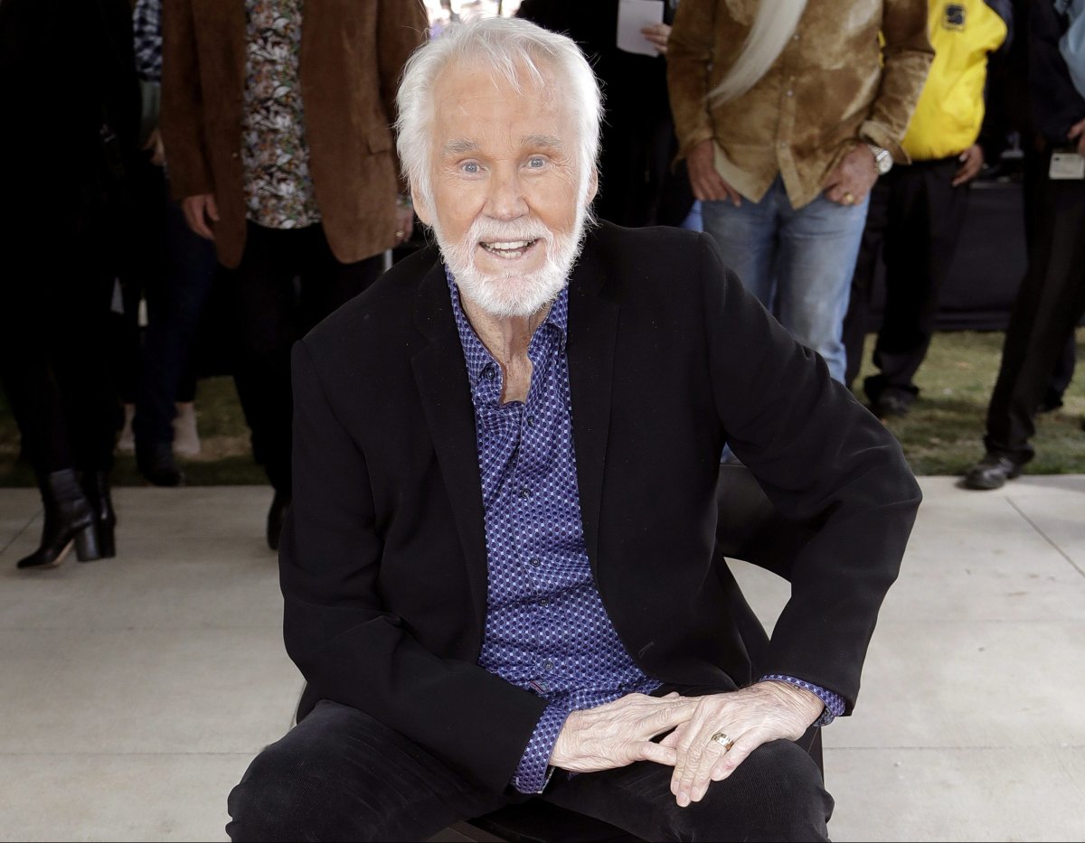 In this Oct. 24, 2017 file photo, Kenny Rogers poses with his star on the Music City Walk of Fame in Nashville, Tenn.