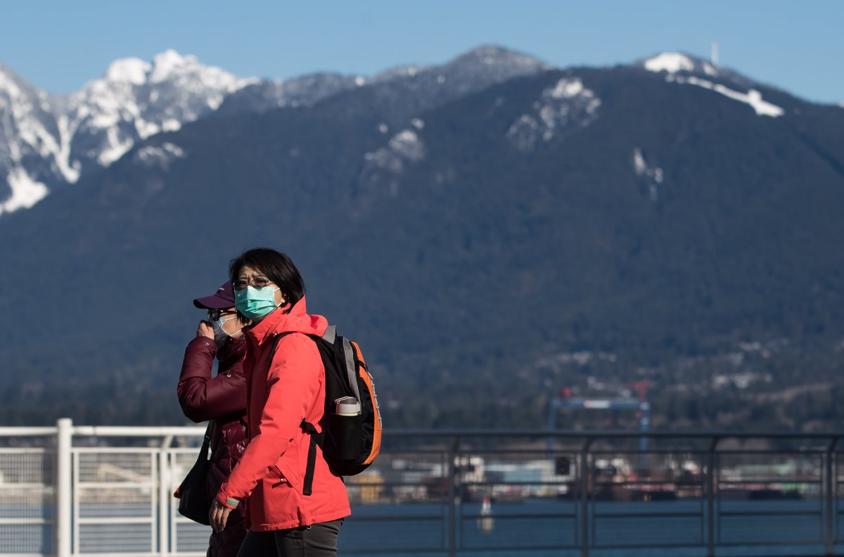 A woman wearing a mask walks in Vancouver in this undated file photo.